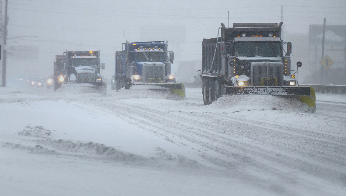 Snow plows amid falling snow