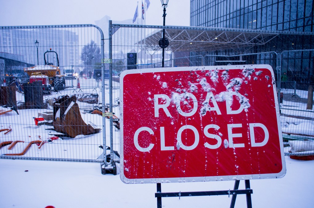 road closed sign covered in snow