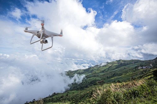 drone flying above smoky hillside