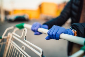 woman wearing gloves pushing shopping cart