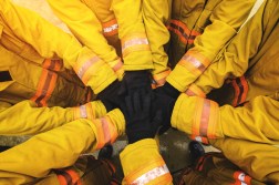 Fire fighters with hands in center of circle