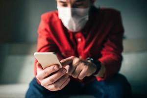 guy with face mask and iphone