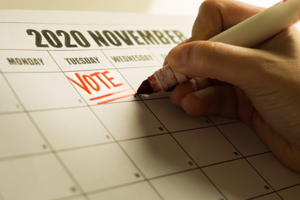 Calendar with someone writing vote on Election Day