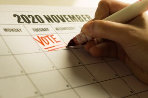 Calendar with someone writing vote on Election Day