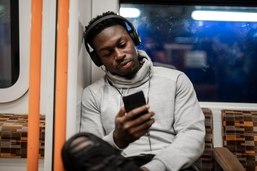 man riding train on smartphone