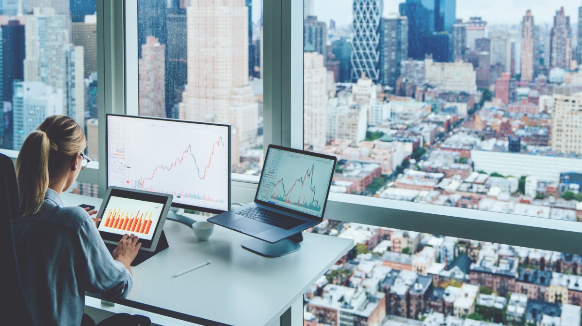 woman sitting near office window, looking at charts