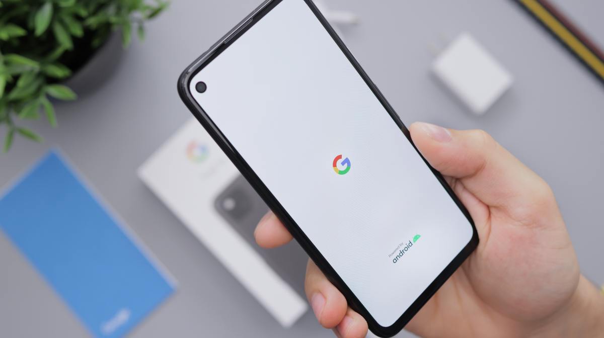 hand holding smartphone with Google logo