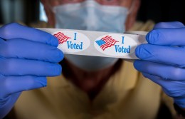 person holding up "I Voted" stickers