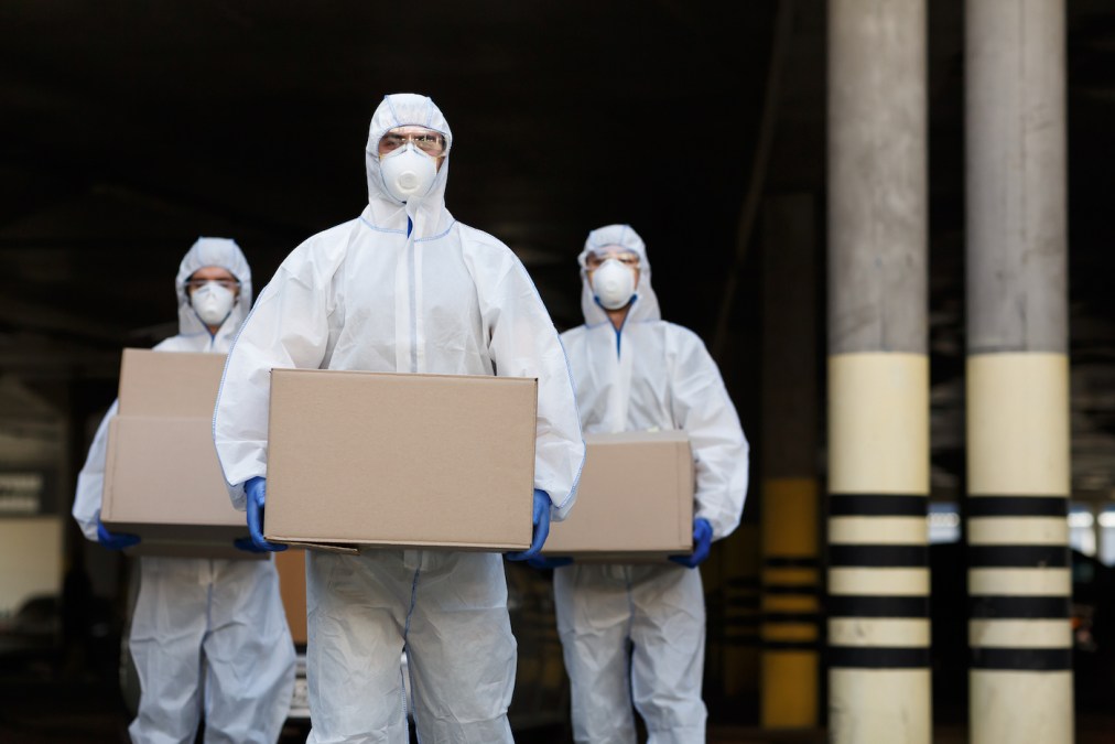 People in protective suits and masks delivering vaccine