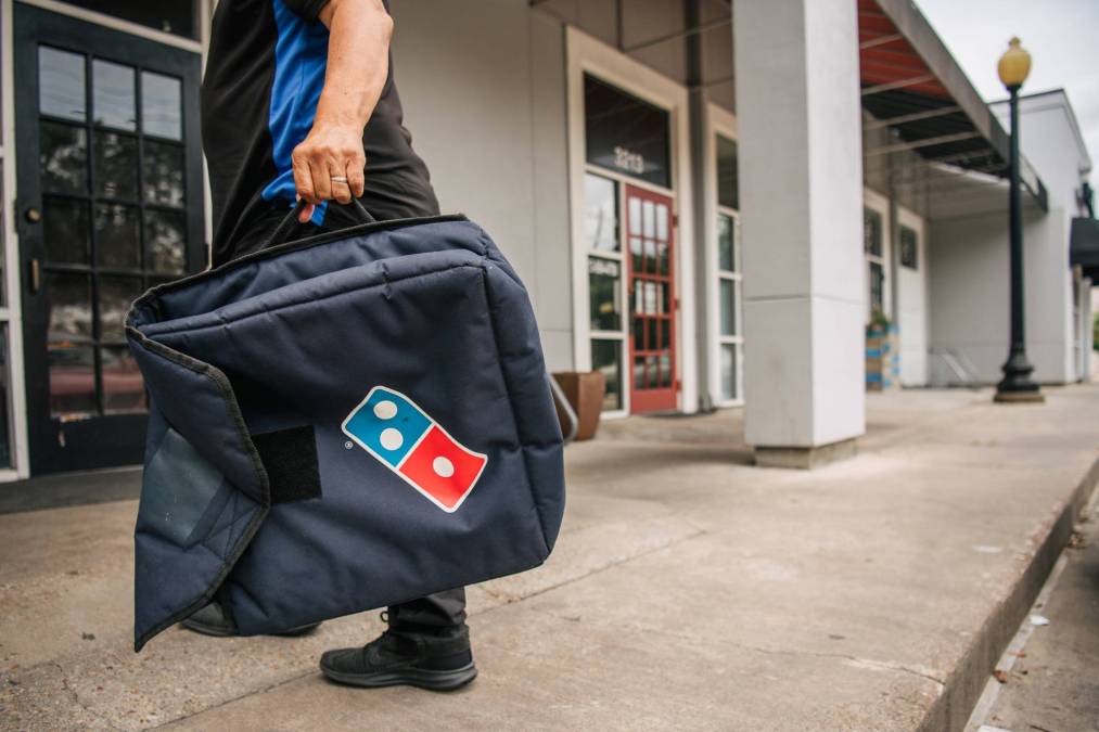 man holding Domino's Pizza delivery bag