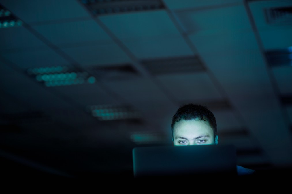 person on computer in dark room