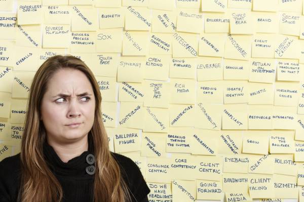 woman standing in front of sticky notes with buzzwords