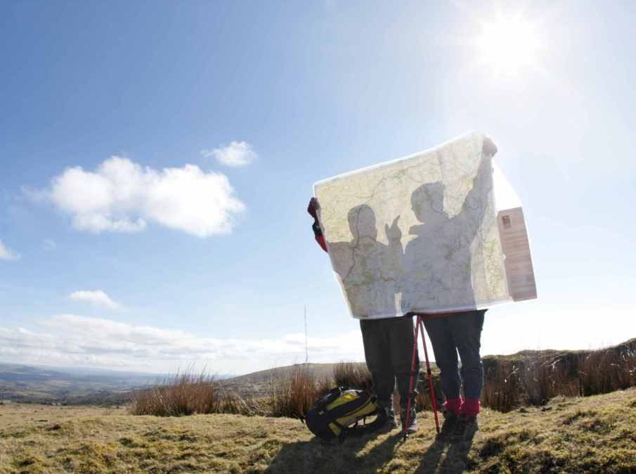 photograph of two hikers looking at map