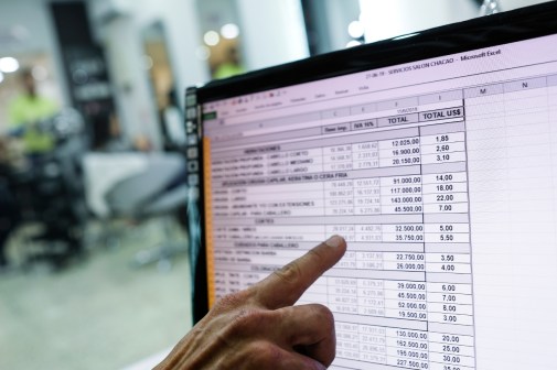 finger pointing at spreadsheet