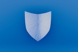 A visually striking blue background showcasing a shield with crack patterns, reflecting concepts of security, protection, and vulnerability in an artistic expression.