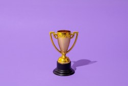 Close up of winner champion gold cup trophy on purple background. Harsh light. Concept of winner, victory, champion, world champion, sport.
