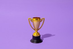 Close up of winner champion gold cup trophy on purple background. Harsh light. Concept of winner, victory, champion, world champion, sport.
